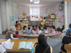 子供達が集まって絵本の読み聞かせを聞いている画像