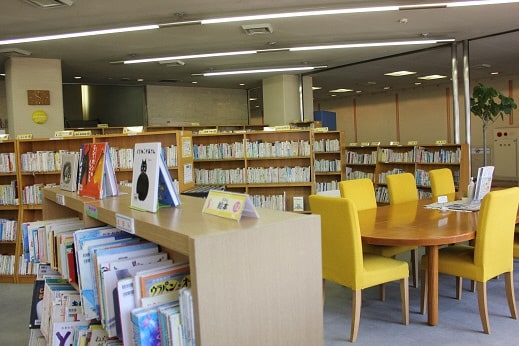 図書室閲覧席と書架の画像